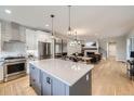 Open-concept kitchen featuring an island, stainless steel appliances, and seamless flow into the living spaces at 21261 E 60Th Ave, Aurora, CO 80019