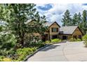 Charming home with a long driveway and mature landscaping providing a welcoming entrance at 648 Ruby Trust Dr, Castle Rock, CO 80108