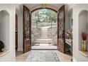 Grand foyer featuring stone floors, stone staircase and arched doorway offering a glimpse of the landscape at 648 Ruby Trust Dr, Castle Rock, CO 80108
