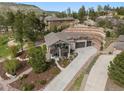 Stunning aerial view of home with an inviting driveway, lush landscaping, and hillside terraces at 20243 High Pines Dr, Monument, CO 80132