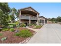 Lovely exterior of two-story home with a large deck, landscaping, and a three-car garage at 20243 High Pines Dr, Monument, CO 80132