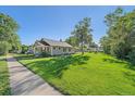Charming home featuring a lush green lawn with shade trees and a welcoming covered front porch at 5614 Yarrow St, Arvada, CO 80002