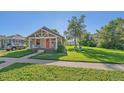 Cozy home featuring a covered porch, lush lawn with shade tree, and a welcoming red front door at 5614 Yarrow St, Arvada, CO 80002