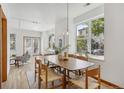 Sunlit dining area with a wooden table, woven chairs, and large windows offering street views at 4632 14Th St, Boulder, CO 80304