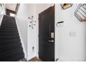 Entryway with a black door and carpeted stairs, showcasing modern lighting and an alarm system at 2602 W 24Th Ave # 6, Denver, CO 80211