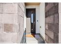 Close-up of the modern front door with brick surround and neutral-colored welcome mat at 2602 W 24Th Ave # 6, Denver, CO 80211