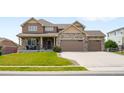 Beautiful two-story house with stone accents, a well-manicured lawn, and an attached three-car garage at 17378 W 78Th Dr, Arvada, CO 80007