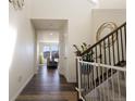 Inviting foyer with hardwood floors, staircase, and views of the front living area through large windows at 10962 Vaughn St, Commerce City, CO 80022