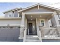 Close up of the covered front porch showcasing stylish pillars, lighting, and a decorative front door wreath at 10962 Vaughn St, Commerce City, CO 80022