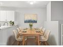 Bright dining room with modern table, seating for eight, and stylish decor featuring an artful painting at 7434 Singing Hills Ct, Boulder, CO 80301