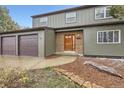 Two-story home featuring an attached three-car garage, brick accents, and a well-maintained front yard at 11864 E Idaho Dr, Aurora, CO 80012
