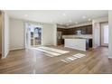 Bright and airy living room with wood floors and a view of the modern kitchen at 21185 E 62Nd Ave, Aurora, CO 80019