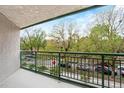 Outdoor balcony overlooking lush greenery, a street, and nearby parking at 550 E 12Th Ave # 209, Denver, CO 80203