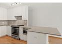 Bright kitchen featuring stainless steel appliances, mosaic tile backsplash and modern white cabinetry at 550 E 12Th Ave # 209, Denver, CO 80203