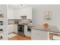 Modern kitchen featuring stainless steel appliances, gray countertops, and ample cabinet space for storage at 550 E 12Th Ave # 209, Denver, CO 80203