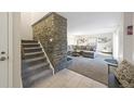 Bright entryway with stone accent wall and view of living room at 6100 W Mansfield Ave # 24, Denver, CO 80235