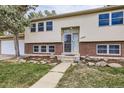 House front entry with brick and stone accents, landscaping and walkway at 12946 Andrews Dr, Denver, CO 80239