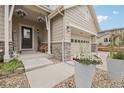 Inviting front porch showcasing stone accents, a welcoming entrance, and an attached two-car garage at 16226 W 94Th Dr, Arvada, CO 80007