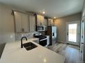 This kitchen boasts modern appliances, sleek gray cabinets, and stunning white quartz countertops at 9476 Yampa Ct, Commerce City, CO 80022