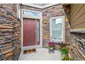 Inviting front entrance featuring a stylish door, stone accents, and colorful potted plants at 15079 E Poundstone Pl, Aurora, CO 80015