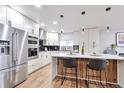 Modern kitchen with stainless steel appliances, white cabinets, and large island with bar seating at 1724 W 40Th Ave, Denver, CO 80211