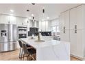 Bright kitchen features white cabinets, stainless steel appliances, and a large island with bar seating at 1724 W 40Th Ave, Denver, CO 80211