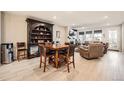Open-concept dining area with a dark wood bookcase, a table set for four, and seamless access to the living room at 4051 Happy Hollow Dr, Castle Rock, CO 80104