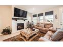 Cozy living room featuring a marble fireplace, plush seating, and large windows for natural light at 4051 Happy Hollow Dr, Castle Rock, CO 80104
