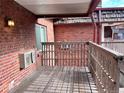 Small wooden deck with brick wall and railing at 5491 E Warren Ave # 217, Denver, CO 80222