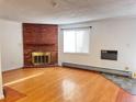 Spacious living room with hardwood floors and brick fireplace at 5491 E Warren Ave # 217, Denver, CO 80222