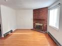 Living room with hardwood floors and brick fireplace at 5491 E Warren Ave # 217, Denver, CO 80222