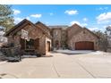 Beautiful two-story stone home featuring a spacious driveway and three-car garage at 651 Ruby Trust Dr, Castle Rock, CO 80108