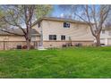 Spacious backyard with lush lawn, mature trees, and partial view of the home's exterior at 9195 E Lehigh Ave # 162, Denver, CO 80237