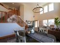 Inviting living room with staircase, chandelier lighting, and large windows at 4765 Larksong Dr, Castle Rock, CO 80109