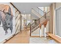 Bright, airy foyer featuring a modern staircase, unique artwork, hardwood floors, and lots of natural light at 481 Meadowleaf Ln, Highlands Ranch, CO 80126