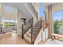 Modern staircase with metal railings, wood accents, and large windows providing ample natural light into the open-concept home at 481 Meadowleaf Ln, Highlands Ranch, CO 80126