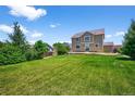 Expansive backyard featuring a lush green lawn and mature trees at 35 N Newcastle Ct, Aurora, CO 80018