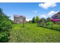 Large, green backyard with a well-maintained lawn and a two-story house in the background at 35 N Newcastle Ct, Aurora, CO 80018