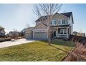 Charming two-story home featuring a three-car garage, inviting front porch, and manicured lawn in a Gathering-friendly neighborhood at 35 N Newcastle Ct, Aurora, CO 80018