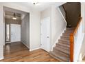 Bright foyer featuring hardwood floors, staircase with wooden banister, coat closet and entry way to the rest of the home at 35 N Newcastle Ct, Aurora, CO 80018