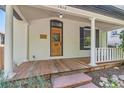 Inviting front porch featuring a wooden deck, brick wall, and charming white columns at 1012 Fillmore St, Denver, CO 80206