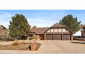 Charming home showcasing a brick facade, well-manicured lawn, mature trees, and a three car garage at 12007 W 54Th Dr, Arvada, CO 80002