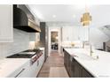 Bright kitchen with stainless appliances, white cabinetry, quartz counters, and a stylish backsplash at 2237 S Madison St, Denver, CO 80210