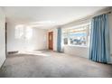 Bright living room featuring large bay windows with curtains and wall-to-wall carpeting at 6369 W 69Th Ave, Arvada, CO 80003