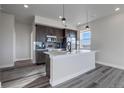 Bright kitchen with a large center island, stainless steel appliances, and modern lighting fixtures at 1208 N Quitman St # 405, Denver, CO 80204