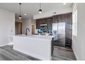 Modern kitchen features sleek appliances, a large island with bar seating, and stylish pendant lighting at 1208 N Quitman St # 405, Denver, CO 80204