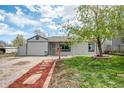 Charming home featuring a well-maintained lawn, mature tree, and unique pathway to the front door at 948 S Tennyson St, Denver, CO 80219