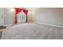Bright living room featuring neutral carpet, large window, and elegant curtains at 2123 S Joplin Way, Aurora, CO 80013