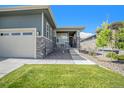 Close-up of the front lawn with a small porch and view of the two-car garage at 1962 Canyonpoint Ln, Castle Pines, CO 80108