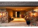 Inviting covered front porch with stone pillars, potted flowers, and seating area at 5020 W Quarles Dr, Littleton, CO 80128